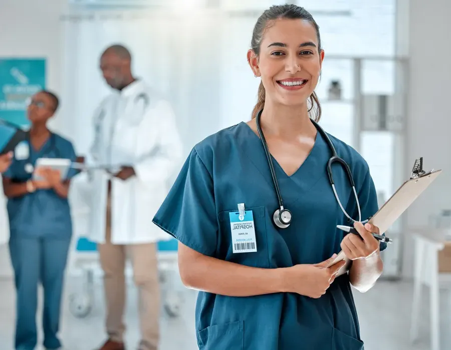 Nurse in Green Scrubs Smiling While Holding Clipboard